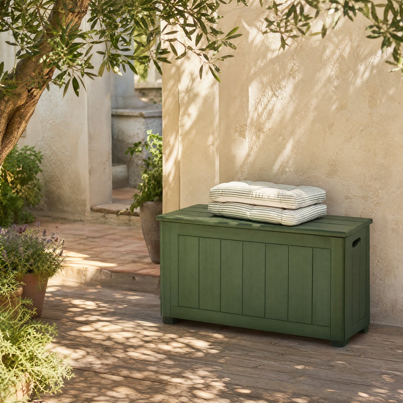 Deck Storage Box, 120 L — a timber deck beside a limewashed wall with this green storage box and folded cushions on top