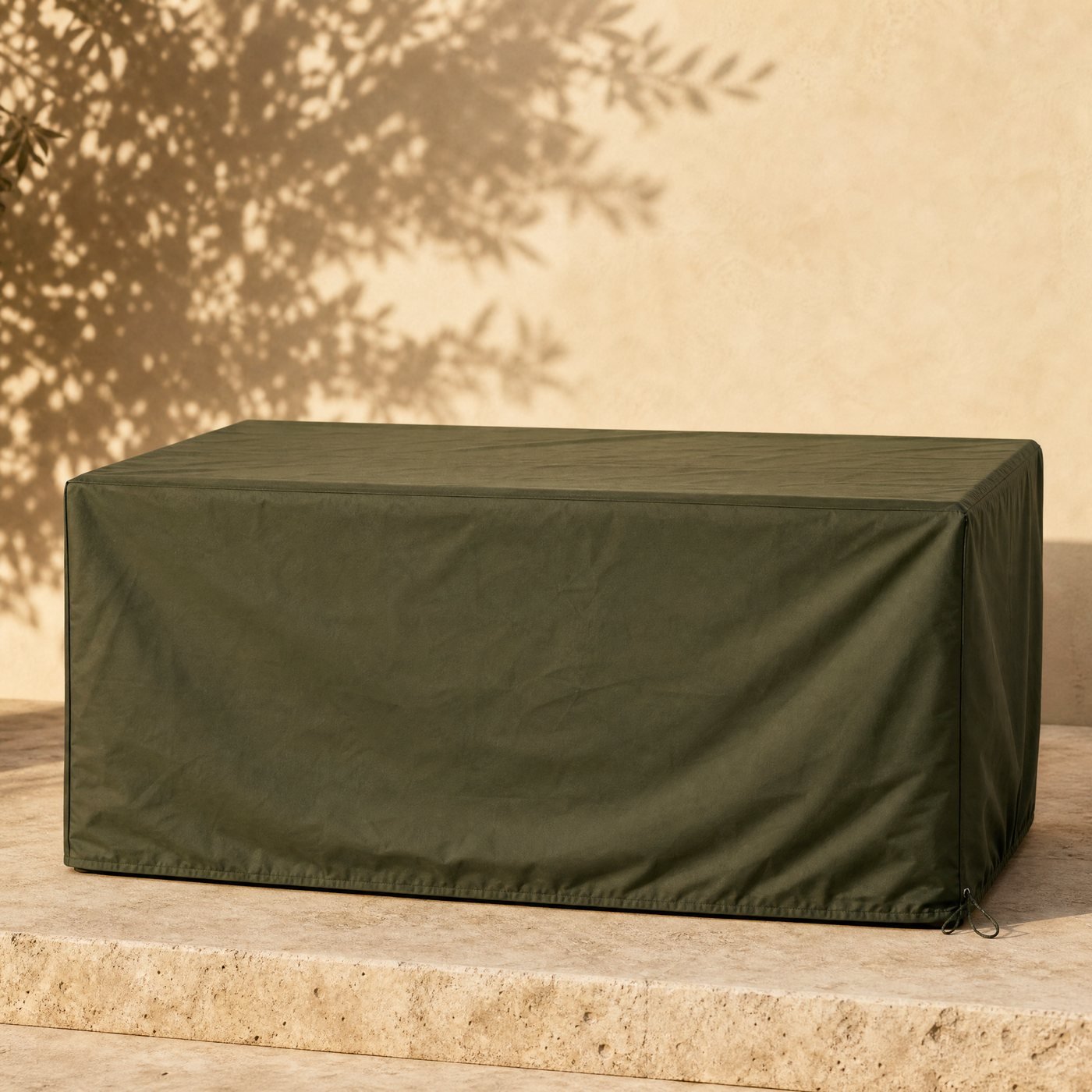 Rectangular Table Cover — a fitted dark olive-green polyester outdoor cover draped over a rectangular garden table, with a drawcord hem