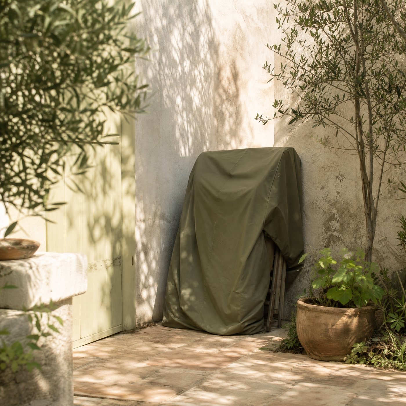 Stacking Chair Cover — a garden corner with this green cover over stacked chairs beside a wall