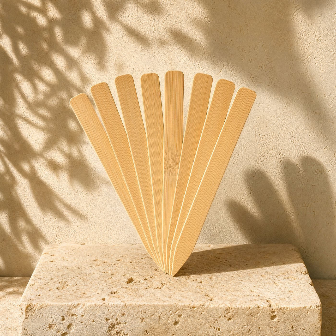 Bamboo Plant Markers, Pack of 50 — a fan of flat pale bamboo plant markers with pointed ends on sunlit stone, blank