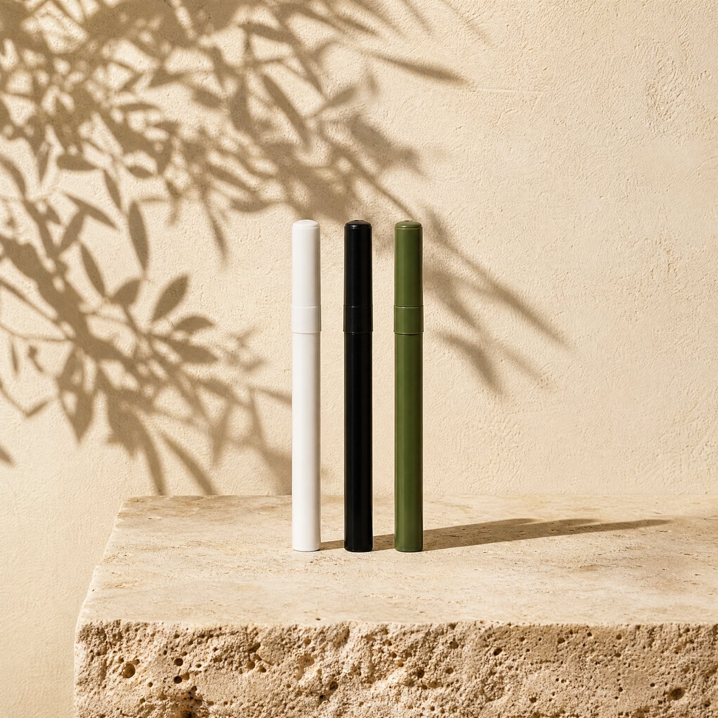 Garden Marker Pens, Set of 3 — three slim paint marker pens with white, black and moss green barrels, caps on, lying in a row on sunlit stone, no writing on them