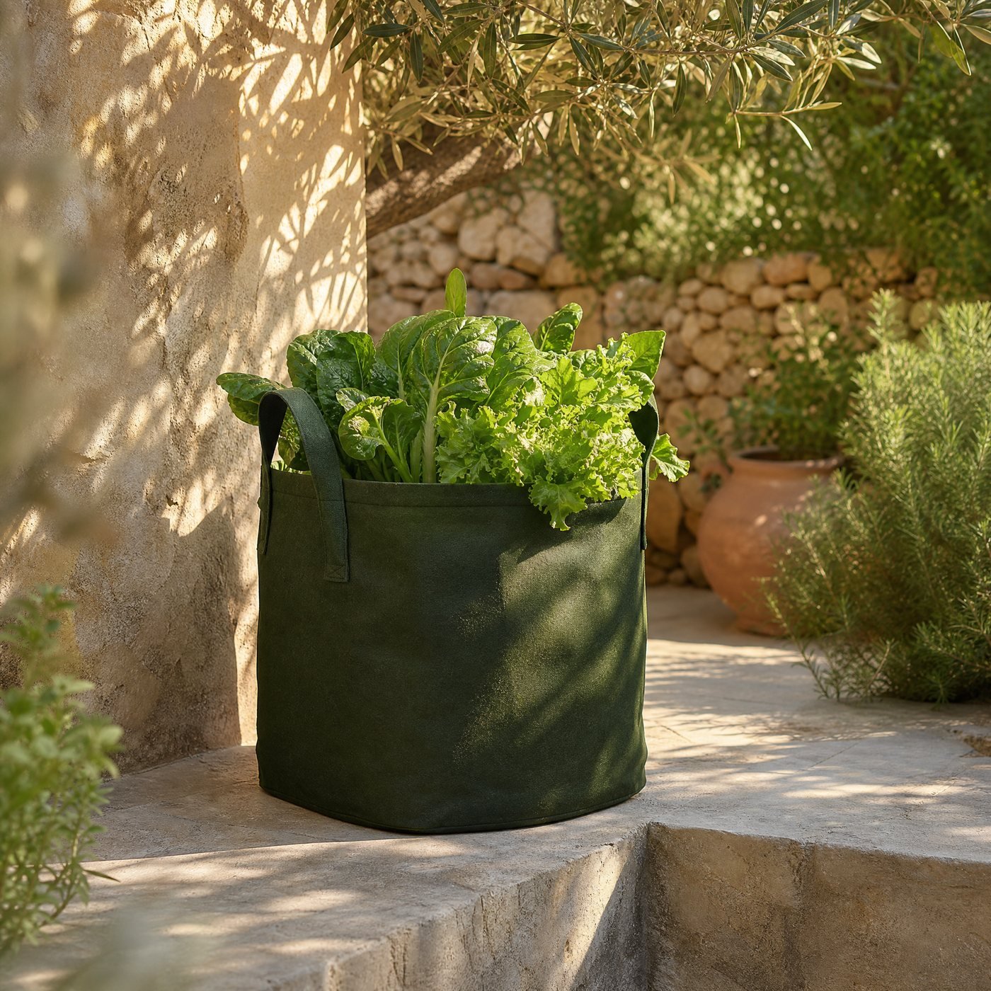 Non-woven Planting Bag with Handles, 40 cm — a raised patio corner with this large fabric bag planted with leafy greens