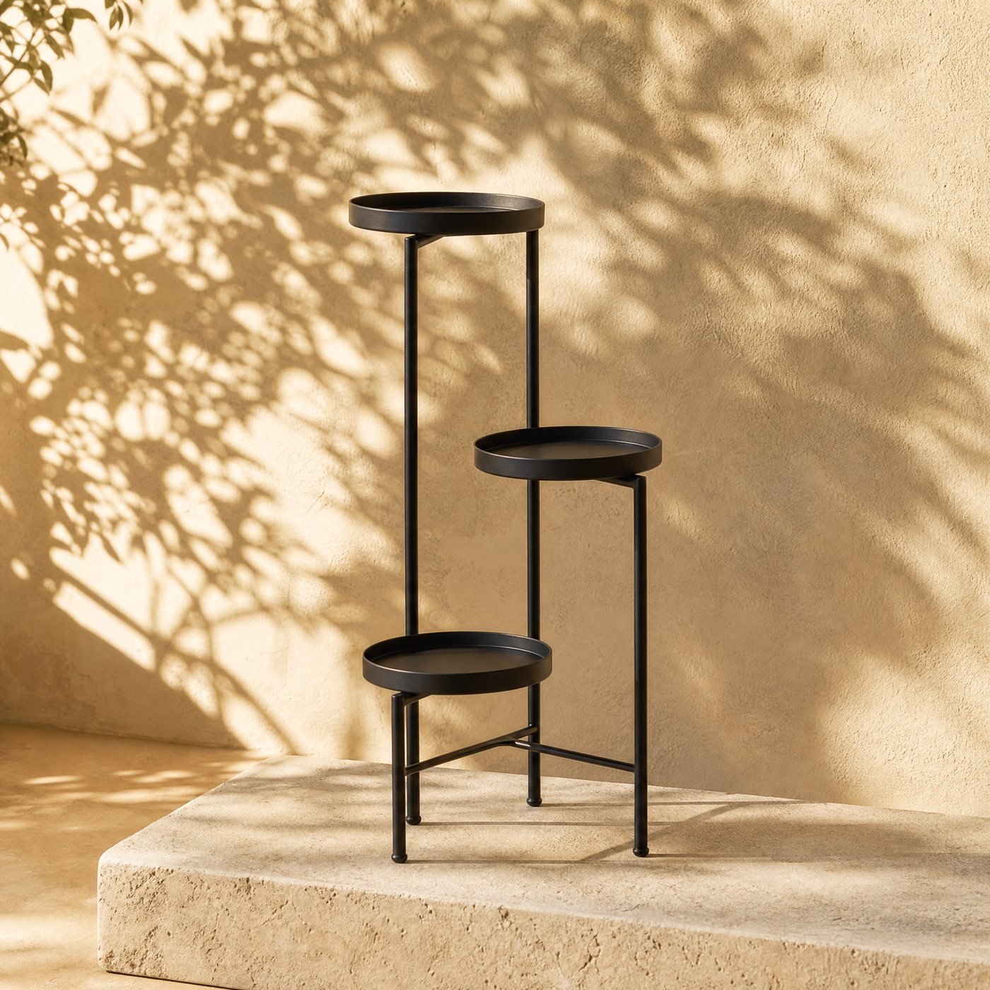Three-tier Steel Plant Stand — a slim matt black powder-coated steel plant stand with three staggered round shelves, empty